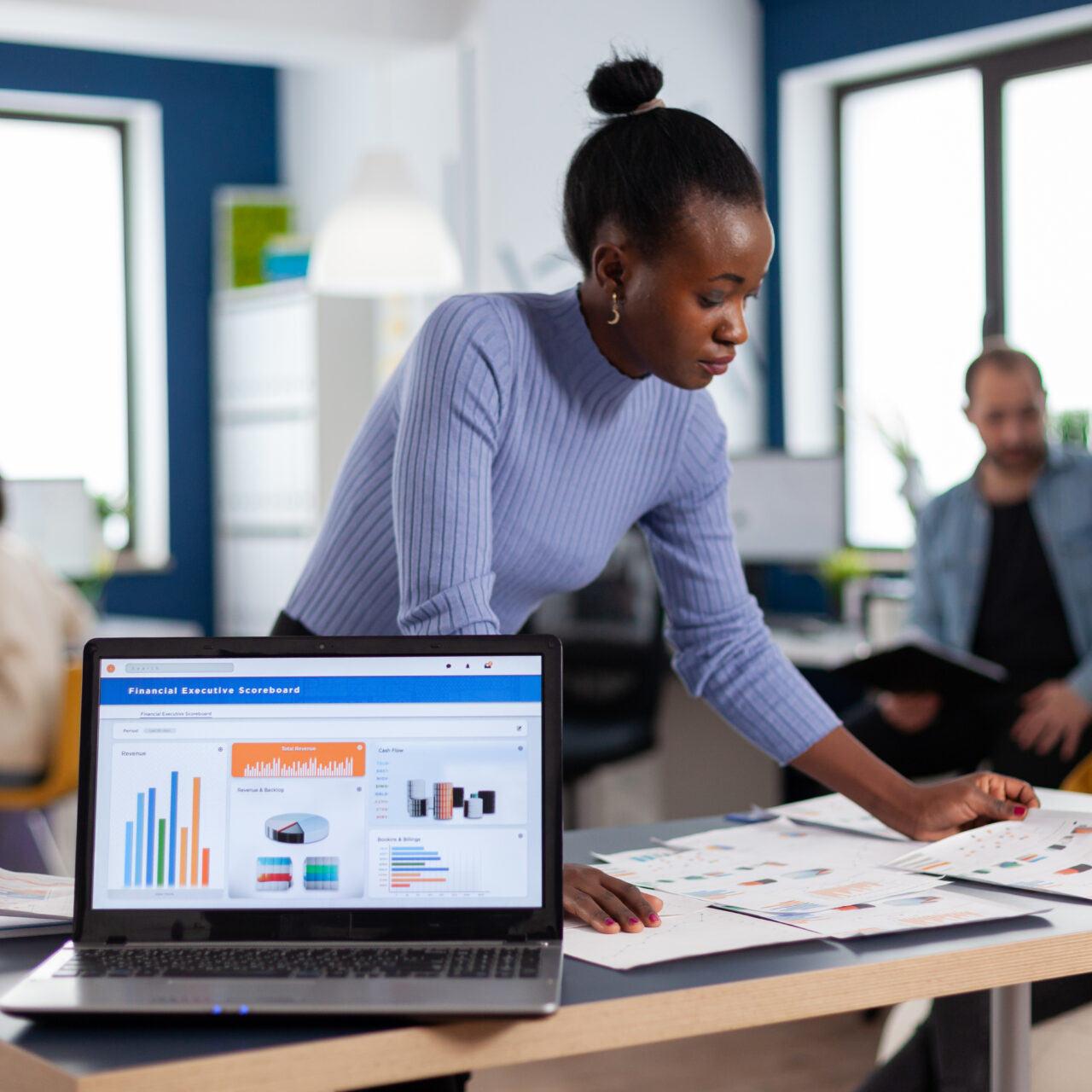 African entrepreneur of start up company reading charts on documents paperwork. Diverse team of business people analyzing company financial reports from computer. Successful corporate professional entrepreneur online internet statistics